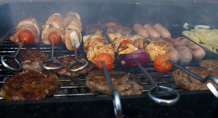 meat cooking in the garden on a barbecue, tasty summer food outdoors 
