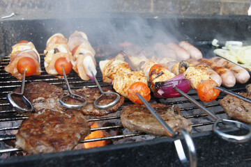 meat cooking in the garden on a barbecue, tasty summer food outdoors 