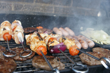 meat cooking in the garden on a barbecue, tasty summer food outdoors 