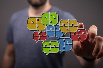 Concept of communication and teamwork with a hand interacting with puzzle speech bubbles, illustrating connection and ideas.