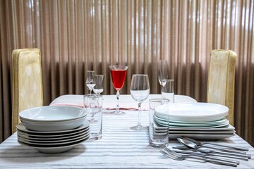 Table set with utensils, empty plate, cutlery, crystal, clean and organized table.
