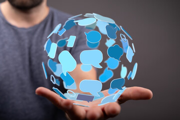 A person presents a floating sphere of communication bubbles, representing global connection and digital networking concepts.