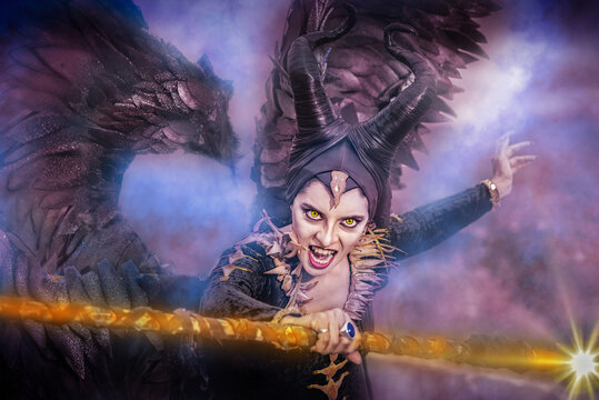 Fantasy portrait of evil fairy in dark costume with horns and wings.