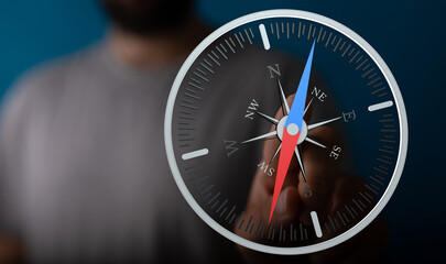 Close up shot of a hand with a compass showing direction. Concept of guidance, navigation, choices,...
