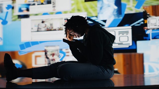 Teenager procrastinating on internet, using social media app on phone instead of doing school assignments. Lazy student using smartphone instead of doing homework, being unproductive, camera B
