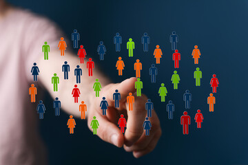Hand pointing towards a group of colorful people icons, symbolizing diversity, teamwork, and...