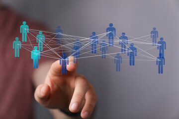 Abstract concept of digital network. Hand pointing to human figures interconnected by lines, representing connection and communication.