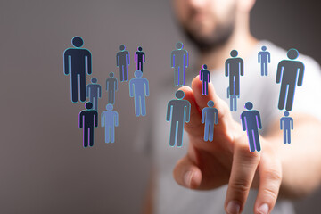 Man's hand pointing towards a network of connected human figures representing networking and...