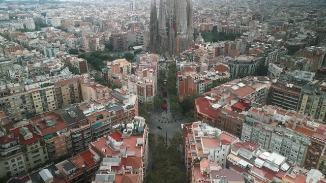 4K drone aerial view of Sagrada Familia and Eixample district in Barcelona, Spain, showing iconic architecture, grid city design and Mediterranean skyline on a sunny day