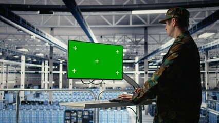 Military data center professional using software on green screen mockup PC to detect enemy threats. Army man in data center uses chroma key computer to detect issues , camera A