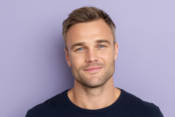 Fototapeta premium Smiling man with short blond hair in a casual shirt against a light purple background looking confident and approachable