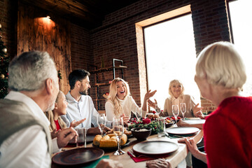 Family gathers for Christmas dinner in a cozy loft style home as loved ones share laughter and festive food during a warm holiday celebration by a lit tree