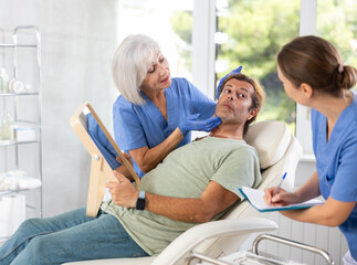 Mature female cosmetologist aesthetician and woman assistant conduct consultation, determine...