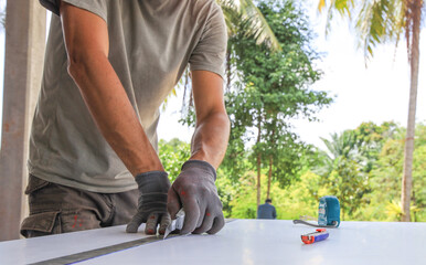 Man is cutting a piece of wood with a saw