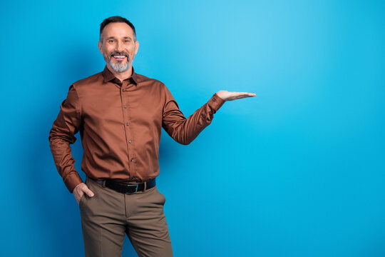 Confident mature businessman in shirt stands against blue background presenting professional corporate image for business stock photo collection