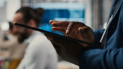 Close up of man reviews performance metrics insights on tablet, driving business strategy and...