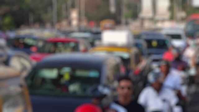 Bokeh view of road traffic near Mahalaxmi suburban railway station in Mumbai, India. Blurred background footage.