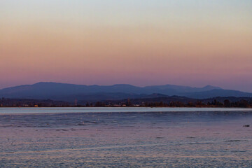 Serene Ocean Sunset with Distant Mountains