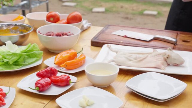Chef preparing traditional peruvian guinea pig meat outdoors