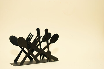 Black metal cutlery holder on beige background