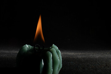 Green candle burning in the dark