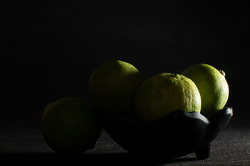 Bowl of green limes in shadow light