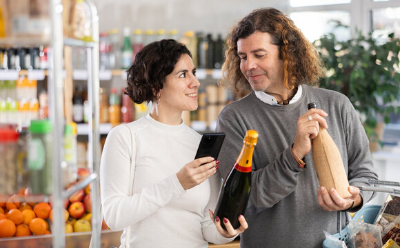 Couple store visitor buyer scan QR code on wine label. In mobile app, client receive information about red wine. Client check manufacturer data in registry database of national agency