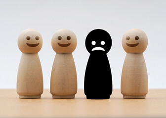 Group of wooden figures with cheerful expressions surrounding a sad figure in a minimalist setting
