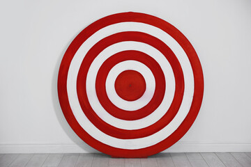 Round shooting target on floor near white wall