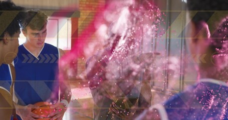 Holding basketball, players in blue uniforms standing on court with pink particles and arrows