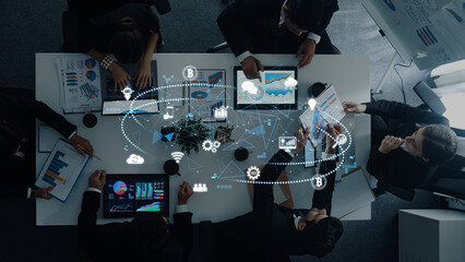 A diverse group of business professionals collaborates in a modern office, analyzing data displayed on digital devices to create strategic insights and foster innovation. Trope