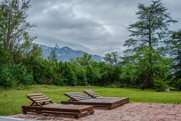 Wooden lounge chairs with mountain view on a cloudy day