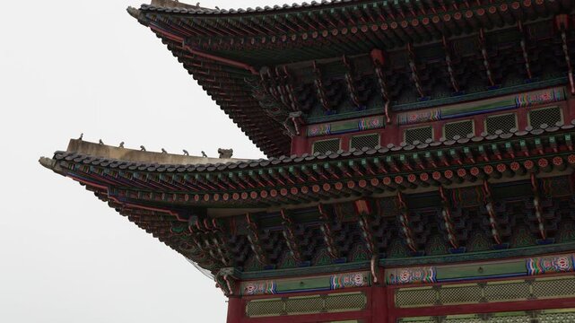 Korean palace roof displaying vibrant dancheong painting and intricate details against a bright sky
