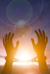 Freedom and liberation concept with broken chain silhouette at sunrise