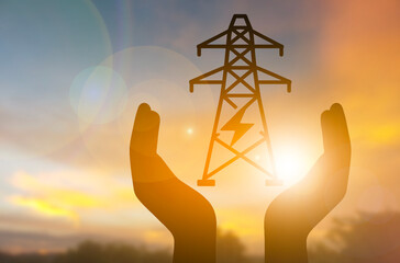 Hands Holding Electric Tower Silhouette at Sunset, Energy and Sustainability Concept