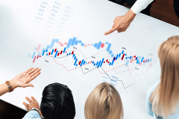 A diverse team engages in collaborative analysis of financial data using graphs and charts in a modern office, showcasing teamwork and strategic decision-making processes. Trope