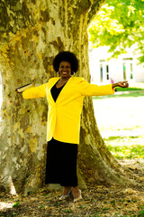 Middle Aged African American Woman Standing Next To Large Tree