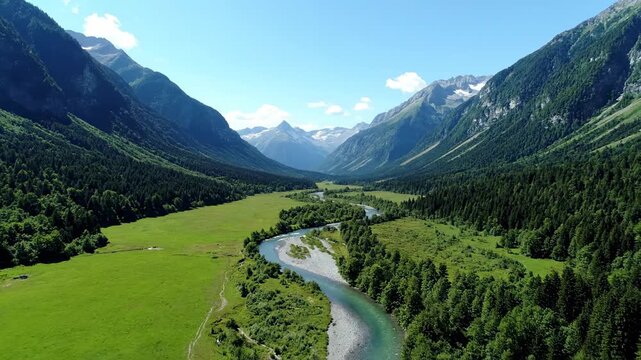A magnificent sweeping aerial drone shot showcasing a winding river gracefully flowing through a vast, pristine green mountain valley freedom, gracefully, water