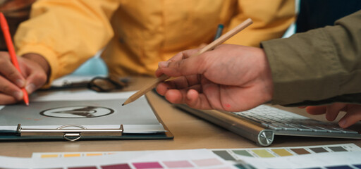 A vibrant collaborative workspace showcases diverse hands engaged in creative discussions. Color...