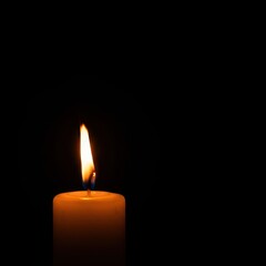 Glowing orange flame atop a white wax candle, creating a beautiful contrast against the deep, dark, empty background ,close up ,memorial ,warm