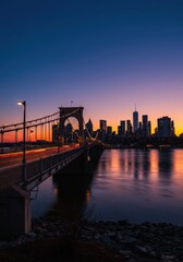 Obraz premium Historic suspension bridge spanning a wide waterway and massive urban skyline illuminated dramatically by the intense, colorful glow of the evening sunset ,massive ,center ,urban landscape