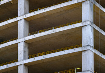 The corner of a multi story concrete building frame under construction showing the unfinished floors and support columns