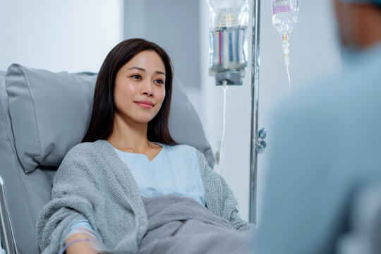 Asian woman rests in hospital bed bathed in gentle light hopeful for recovery and brighter future.
