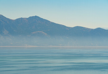 A clear and sharp photograph of a majestic mountain range rising above a calm lake on a bright day a beautiful landscape in Isparta Turkey © bugrakaanersoy