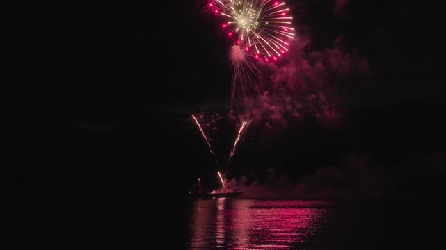 Colorful fireworks exploding above the lake water