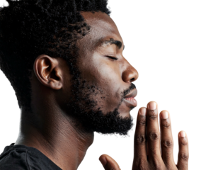 Profile of a man with closed eyes and clasped hands, deep in thought against a dark background