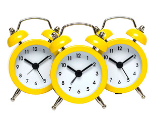 Three bright yellow alarm clocks grouped together, on a black background, showing different times