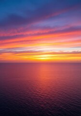 Fototapeta premium A stunning, wide vista showing a brilliant orange and pink tropical sunset descending below the vast horizon of the deep blue ocean water ,ocean ,scenic ,pink