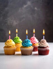 Assorted cupcakes with colorful frosting and lit candles