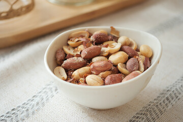 peanuts in a white bowl on a table setting